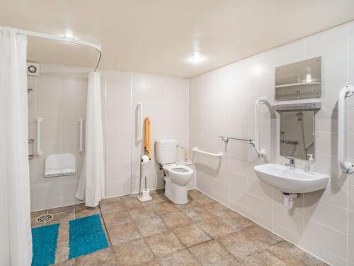 a bathroom with a toilet and a sink at The Barn in Poulton le Fylde