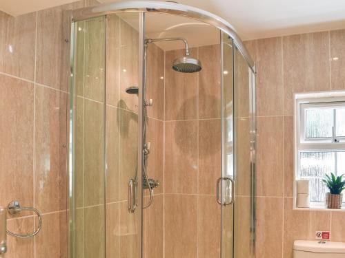 a shower with a glass door in a bathroom at Woodland Retreat in Washaway