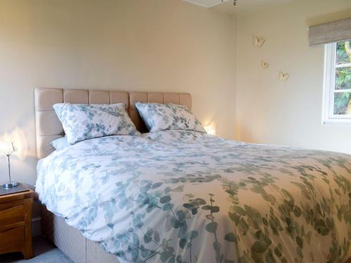1 dormitorio con cama con edredón y ventana en Walkers Lodge, en Hampton Bishop