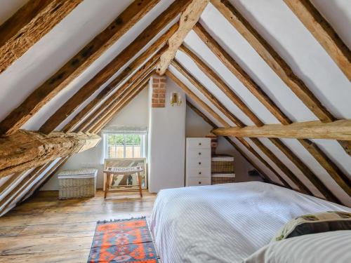 a attic bedroom with wooden beams and a bed at The Restored Cottage in Eccleston