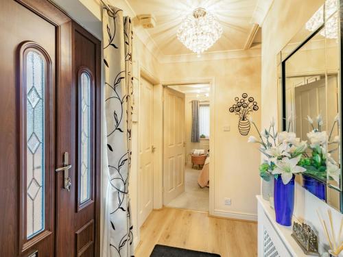 a hallway with a door and a vase of flowers at Berwood Cottage in Epworth