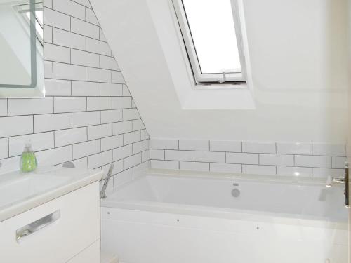 a white bathroom with a tub and a sink at Puxton Lodge in Fordwich