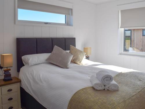 a bedroom with a large white bed with towels on it at Cree Lodge - Uk13636 in Creetown
