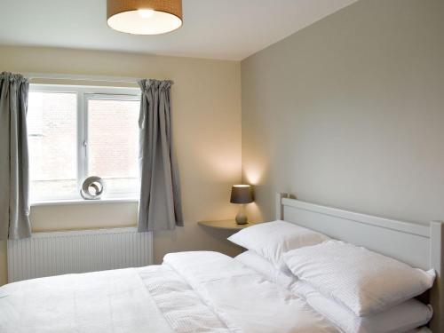 a bedroom with a white bed and a window at Seven Dorchester Drive - Uk32625 in Inglewhite