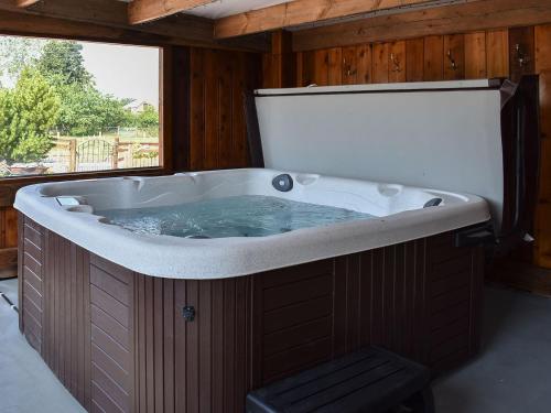 a large bath tub in a room with a window at Country Lodge in Soulby
