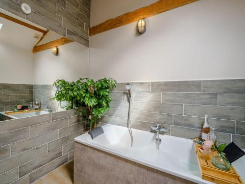 a bathroom with a tub and a sink at The Barnacle Goose - Uk35261 in Bowness-on-Solway