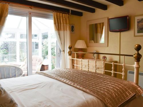 a bedroom with a bed and a sliding glass door at The Swallows in Roche