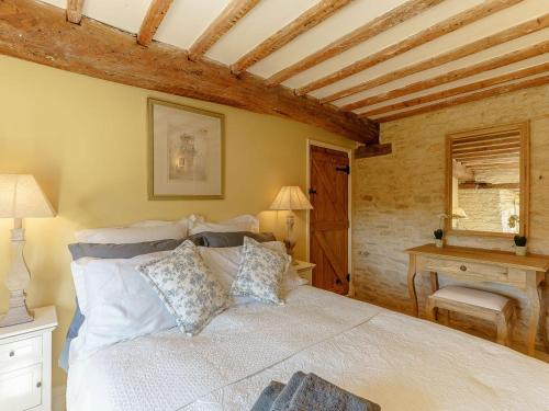 a bedroom with a bed and a table and a window at The Clock House in Bisley