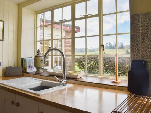 a kitchen with a sink and a large window at Coachmans Close in Milverton