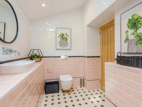 a pink bathroom with a tub and a toilet at Inner Lodge in Bolton by Bowland