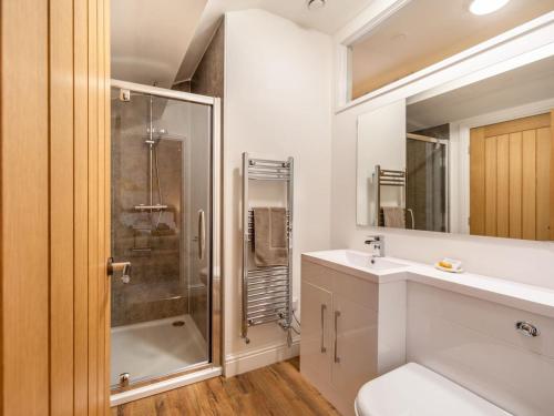 uma casa de banho com um chuveiro, um WC e um lavatório. em Ferny Rigg Byre - Uk3326 em Falstone