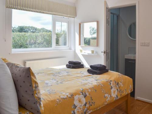 a bedroom with a bed with two towels on it at The Old Creamery in Witheridge