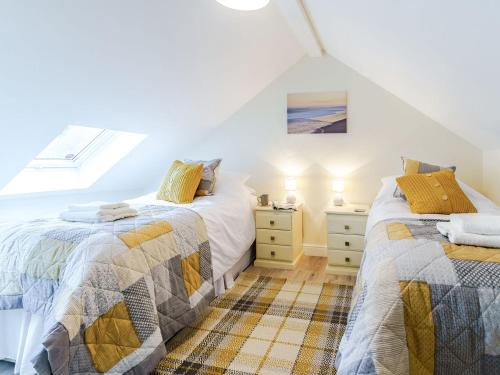 two beds in a room with a window at Ty Draenog - Uk31653 in New Quay