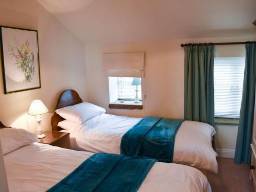 a hotel room with two beds and a window at High Dalton Hall Cottage in Newsham