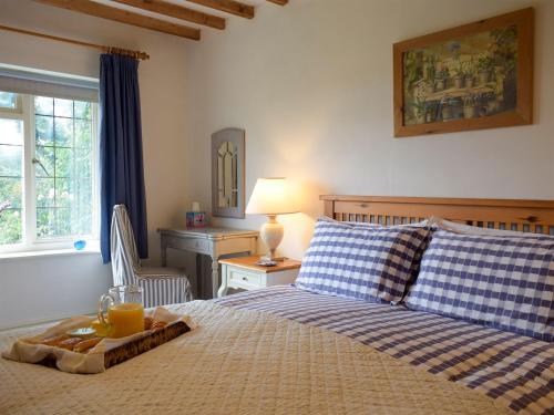 a bedroom with a bed with a tray of orange juice on it at The Cottage in Lane to Richards Castle