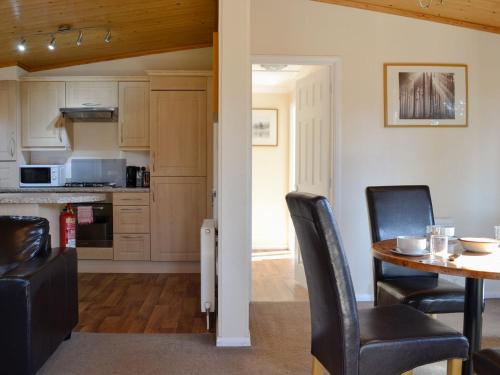 a kitchen and dining room with a table and chairs at Lodge F- Uk33092 in Dinnet