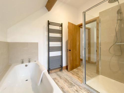 a bathroom with a bath tub and a shower at Smardale Cottage in Crosby Garrett