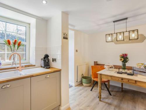 a kitchen and a dining room with a table at Hillside Cottage in Haltwhistle