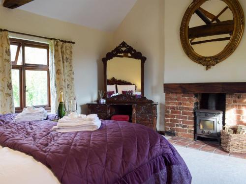 a bedroom with a purple bed and a mirror at Grafton Farm in Loppington