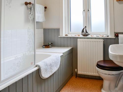 a bathroom with a tub and a toilet and a sink at Sinclairs in Gatehouse of Fleet