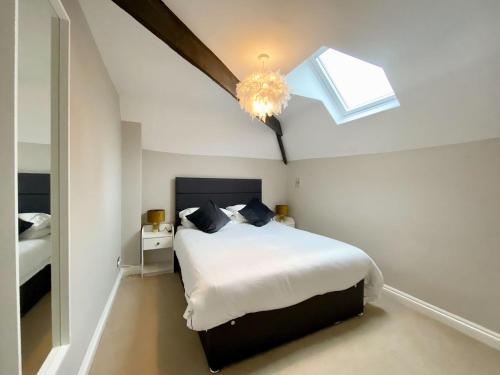 een slaapkamer met een bed en een dakraam bij The Corner Barn in Cirencester