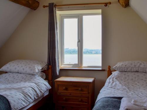 a bedroom with two twin beds and a window at The Coach House in Lydney