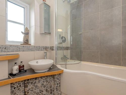 een badkamer met een bad, een wastafel en een douche bij Number 1 Admiralty Cottages in Alverstoke