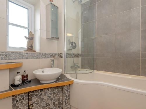 a bathroom with a tub and a sink and a shower at Number 1 Admiralty Cottages in Alverstoke