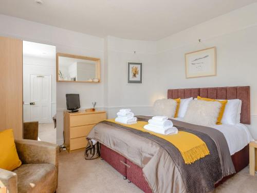 a bedroom with a large bed and a chair at Number 1 Admiralty Cottages in Alverstoke