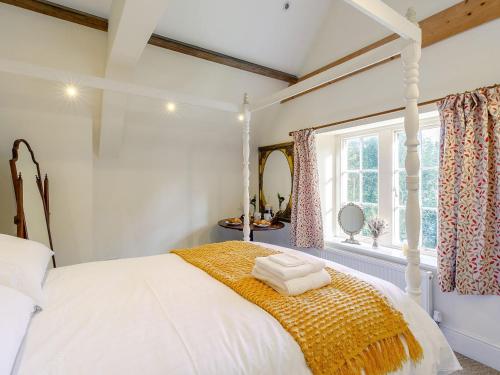 a bedroom with a white bed and a window at Gardeners Cottage - Uk35774 in Fulbeck
