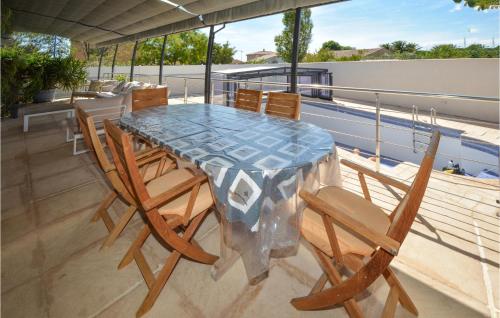 a glass table and chairs on a balcony at Nice Home In Saint-Gilles in Saint-Gilles