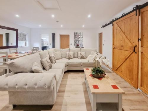 ein Wohnzimmer mit einem weißen Sofa und einem Tisch in der Unterkunft Mac Shack Cottage in Ashen