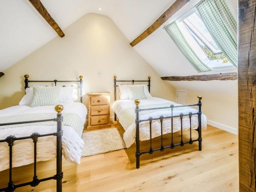 two beds in a attic bedroom with skylights at Pipistrelle - Uk30758 in Bream