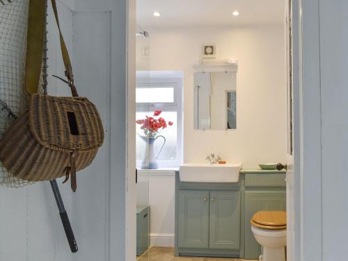 a bathroom with a sink and a toilet and a mirror at Seaton Cottage in Collieston