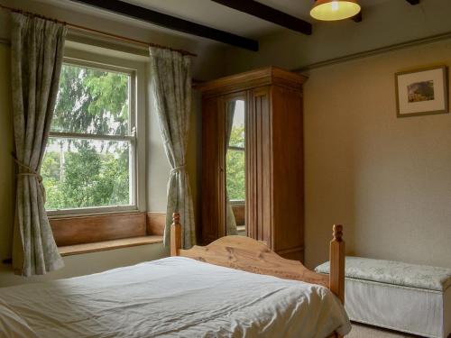 a bedroom with a bed and a window at Thorn Cottage in Spark Bridge