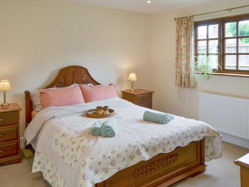 a bedroom with a bed with two towels on it at The Coach House in Great Ryburgh