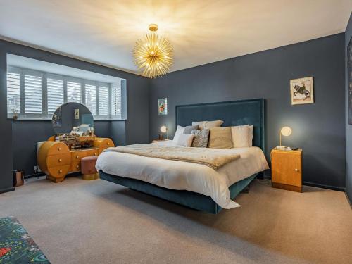 Un dormitorio con una cama grande y una lámpara de araña. en Vallance House en Brighton & Hove