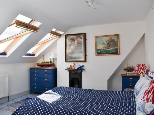 哈里奇的住宿－Fronks House，一间卧室设有天窗、一张床和蓝色橱柜。
