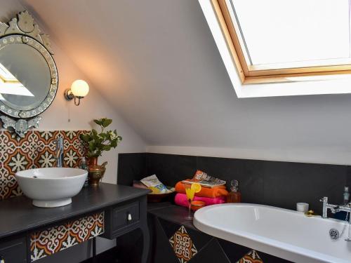 a bathroom with a tub and a sink and a mirror at Fronks House in Harwich