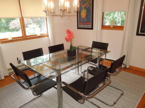 a dining room with a glass table and chairs at Relax in Nature & Serenity at Bird River Cottage! in Middle River