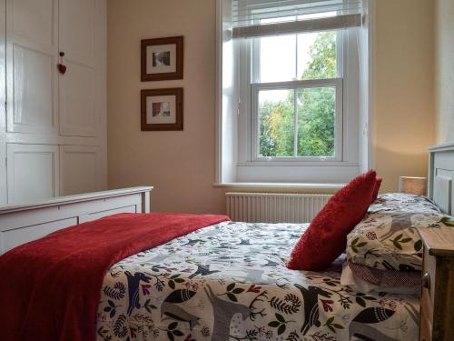 1 dormitorio con cama y ventana en Blaithwaite Cottage, en Blencogo