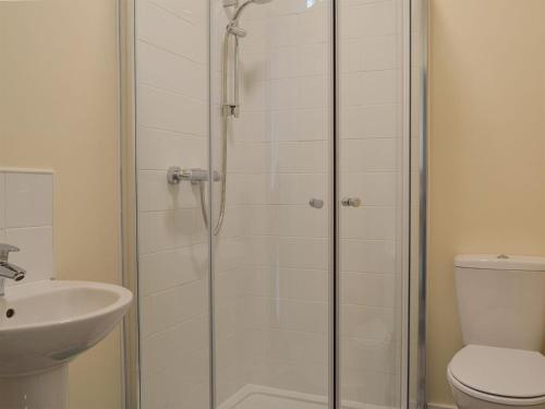 uma casa de banho com um chuveiro, um WC e um lavatório. em Blaithwaite Cottage em Blencogo