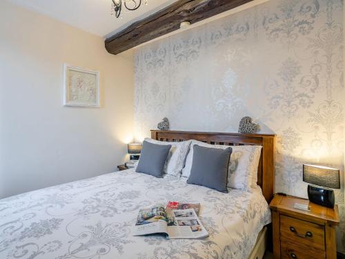 a bedroom with a bed with a book on it at The Miners Rest in Middleton