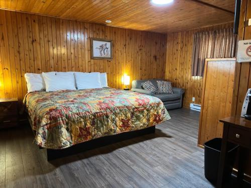a bedroom with a bed and a couch in it at Sunset Motel of St. Ignace in Saint Ignace