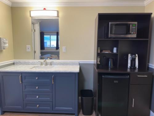 a kitchen with a sink and a microwave at Sunset Motel of St. Ignace in Saint Ignace