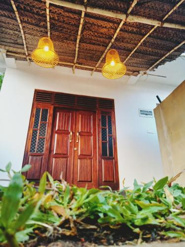 a wooden door in a house with two lights at Surf View Point Ahangama in Ahangama