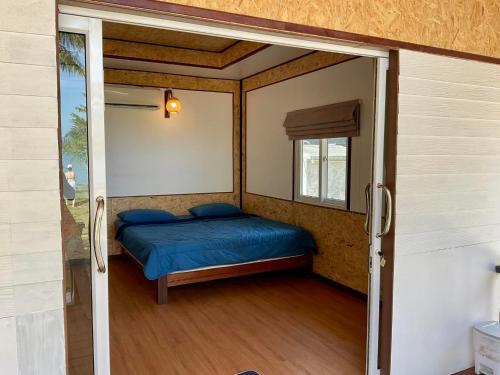 a small bedroom with a bed and a window at Sunrise House in Ko Yao Noi