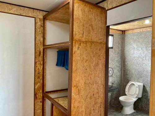 a bathroom with a toilet and a glass door at Sunrise House in Ko Yao Noi