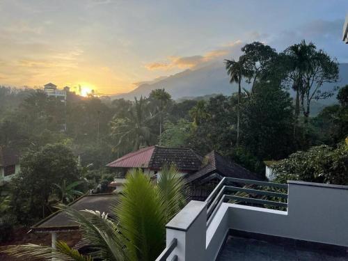 a balcony of a house with the sunset in the background at Peppercorn Cottage, Vythiri. in Vythiri