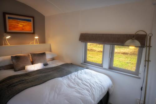 ein Schlafzimmer mit einem Bett und zwei Fenstern in der Unterkunft Onegum Bed and Breakfast in Kendenup